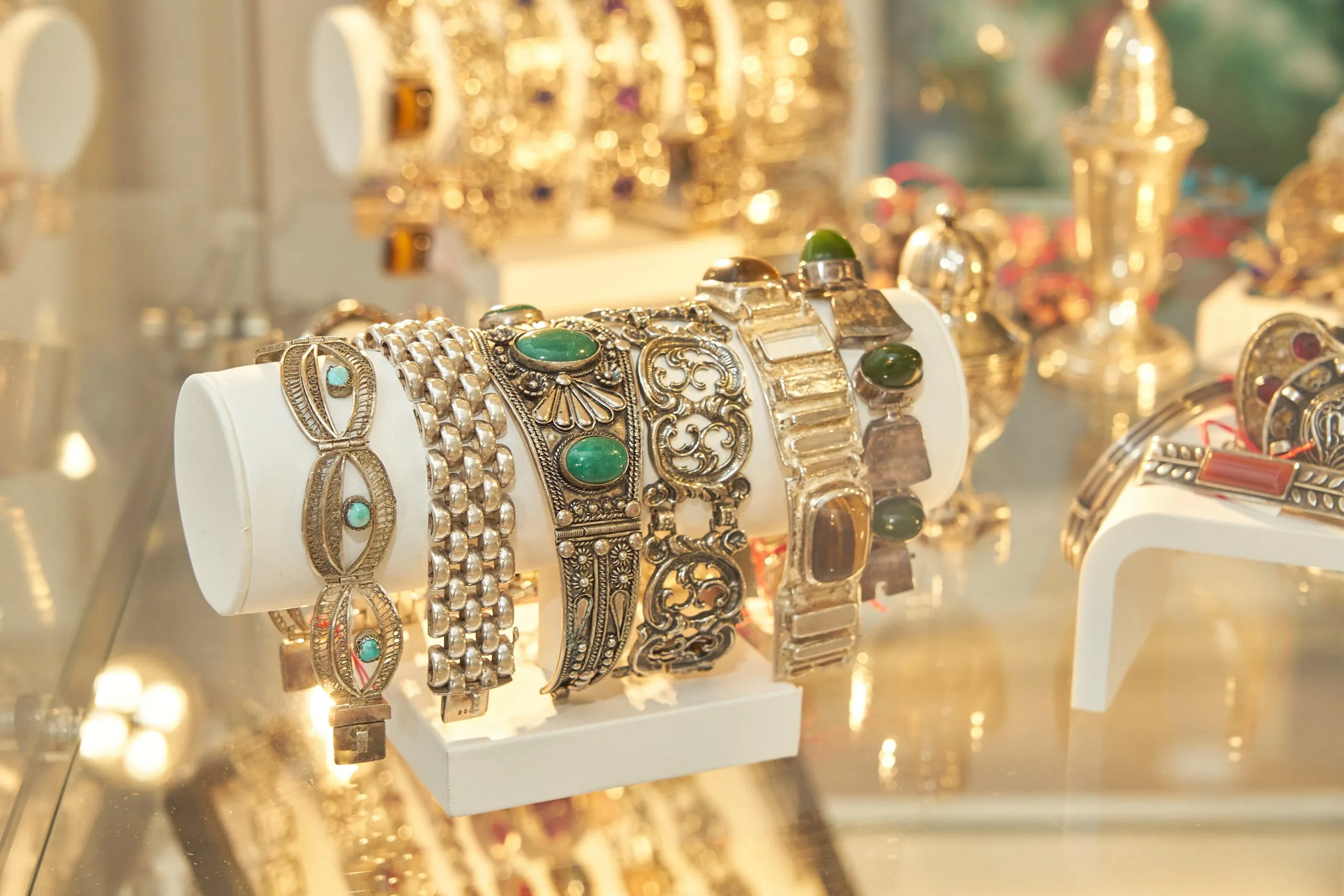 Goldschmuck-Display mit Armbändern und Edelsteinen im Brunswiker Antik Pavillon