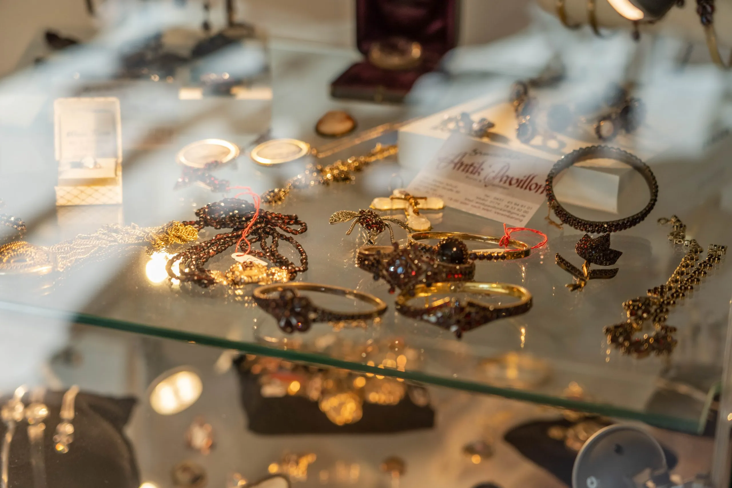 Vitrine mit Granatschmuck und Visitenkarte des Brunswiker Antik Pavillon